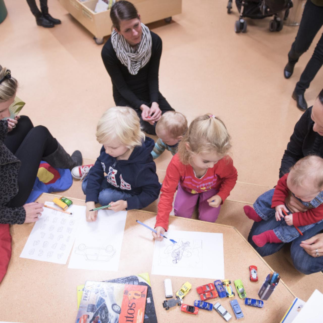 Symbolbild: Eltern mit Kinder in der Bibliothek